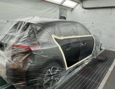 Car being resprayed black in a spray booth in Newquay