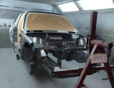 Metal framework of a BMW being prepped for painting in Newquay